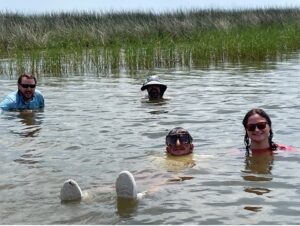 photo of scientists swimming in a marsh