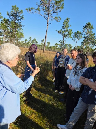 group of people outside looking at a teacher